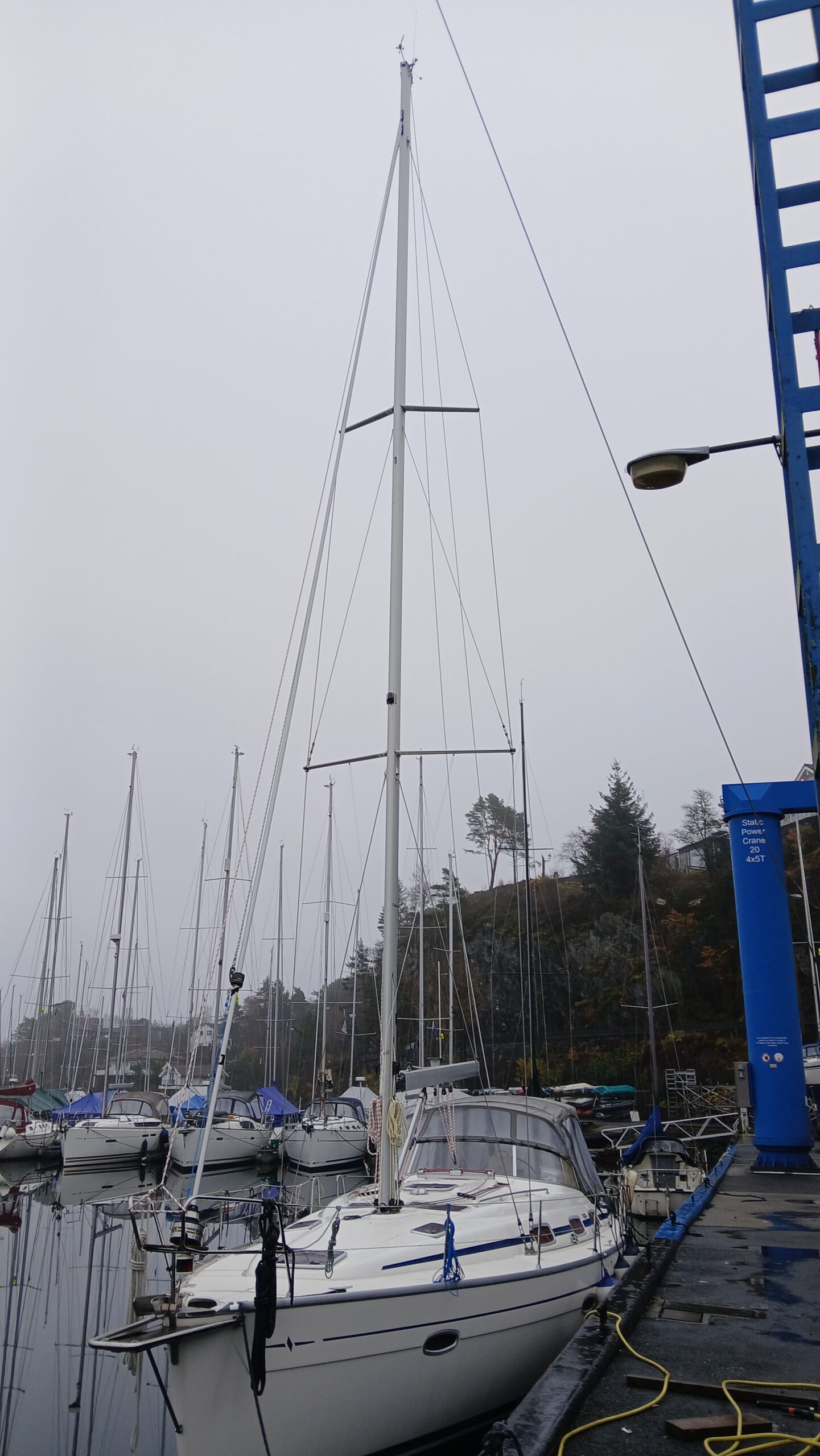 Seilbåt ved kai med mast og tauverk, klar for seilas.